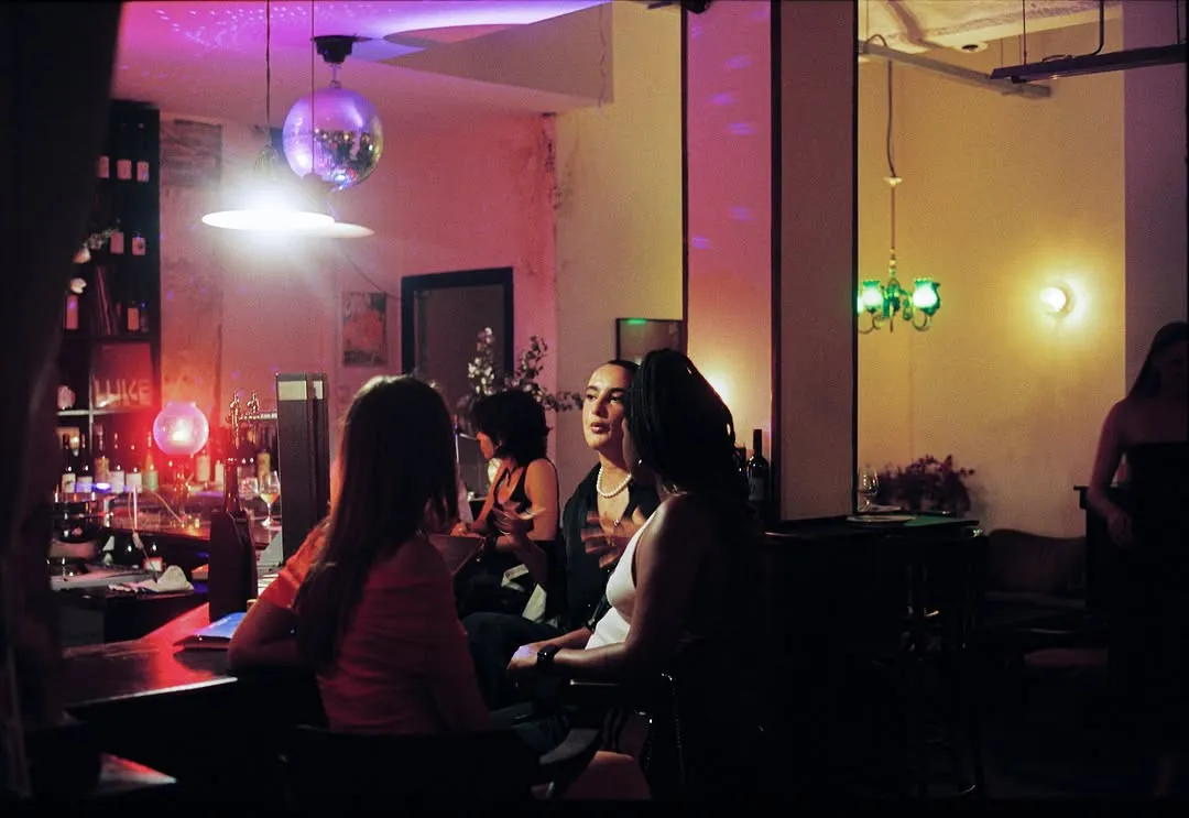 La barra de noche, con luz rosa y una bola de espejos en el techo.