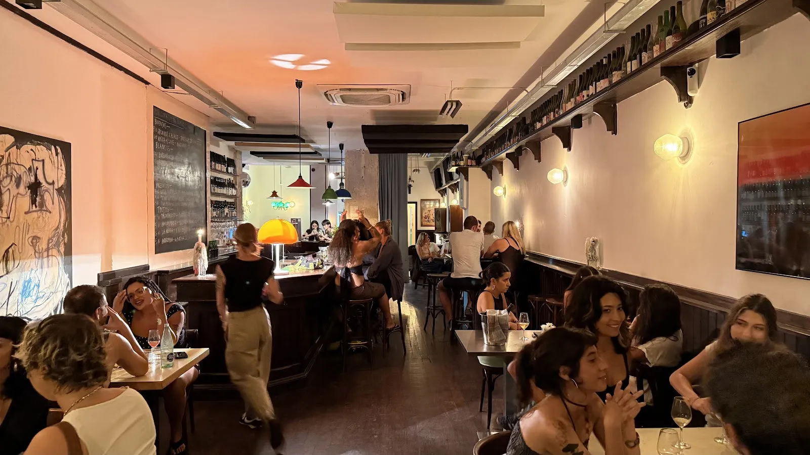 La sala llena de gente, con la barra al fondo.