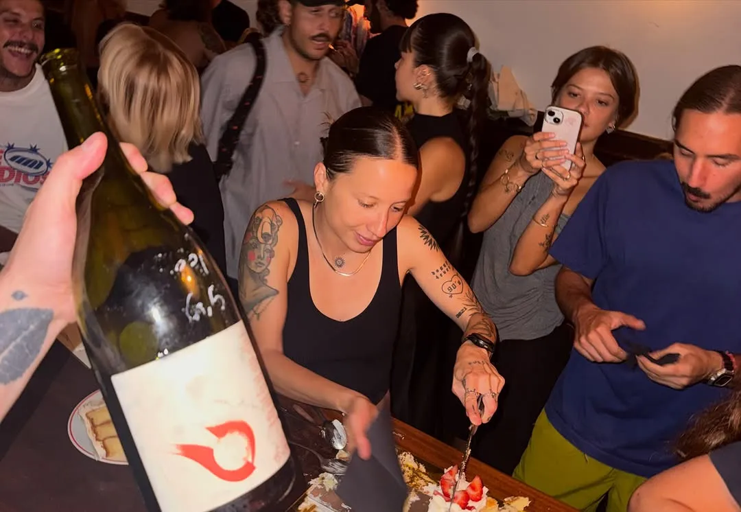 Una noche animada: una botella en primer plano y gente alrededor de la barra.