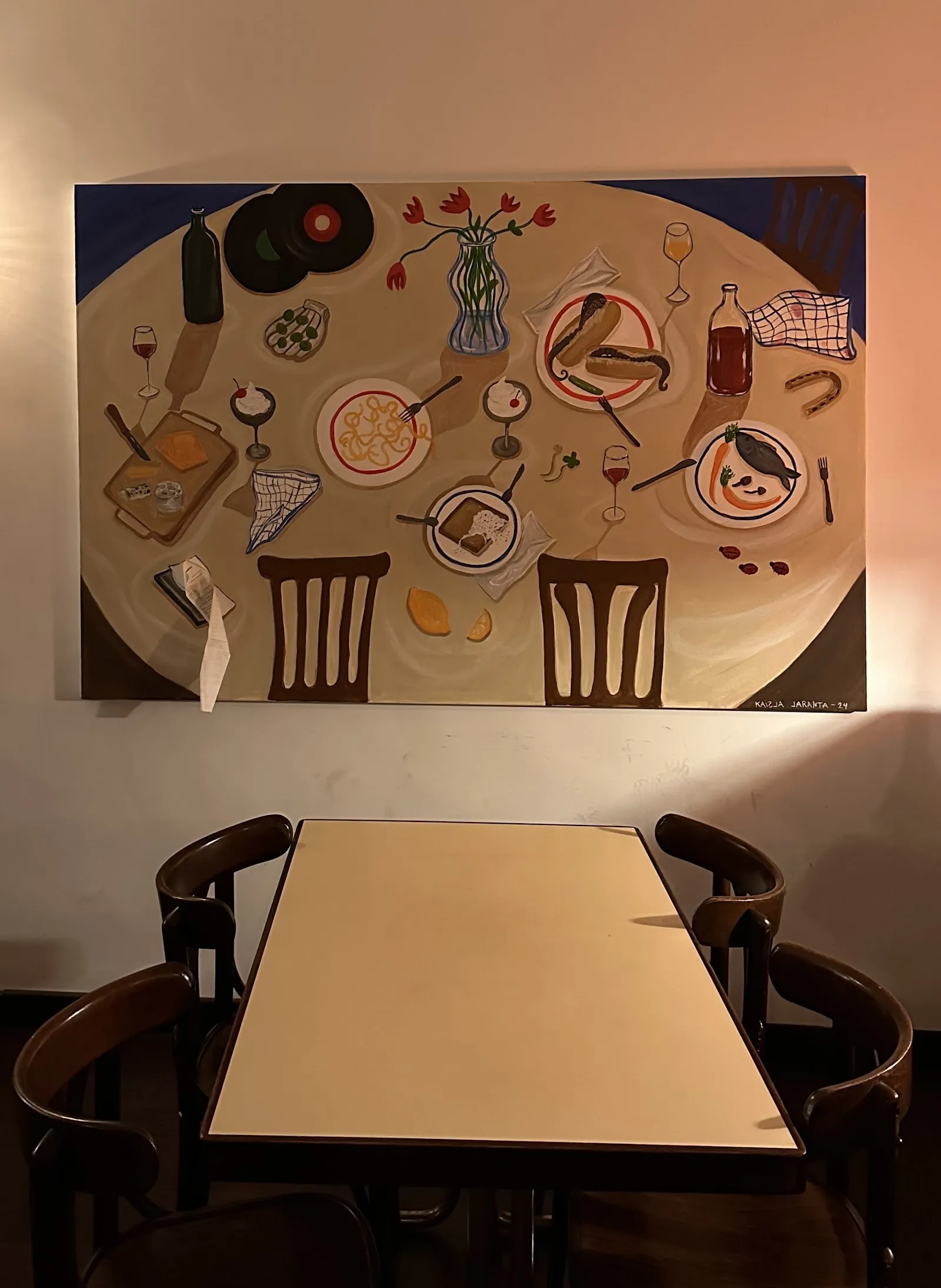 Una mesa bajo un cuadro grande en la sala.