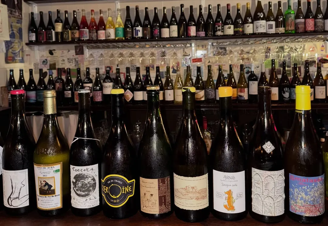 Estantes llenos de botellas de vino natural detrás de la barra.