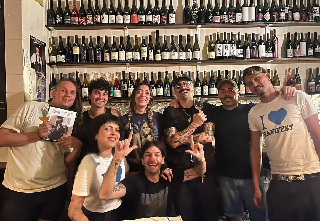 El equipo de Manifest delante de las estanterías de botellas.