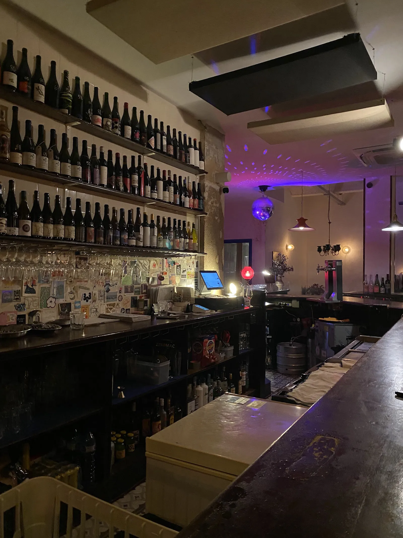 La barra larga con las paredes cubiertas de botellas.